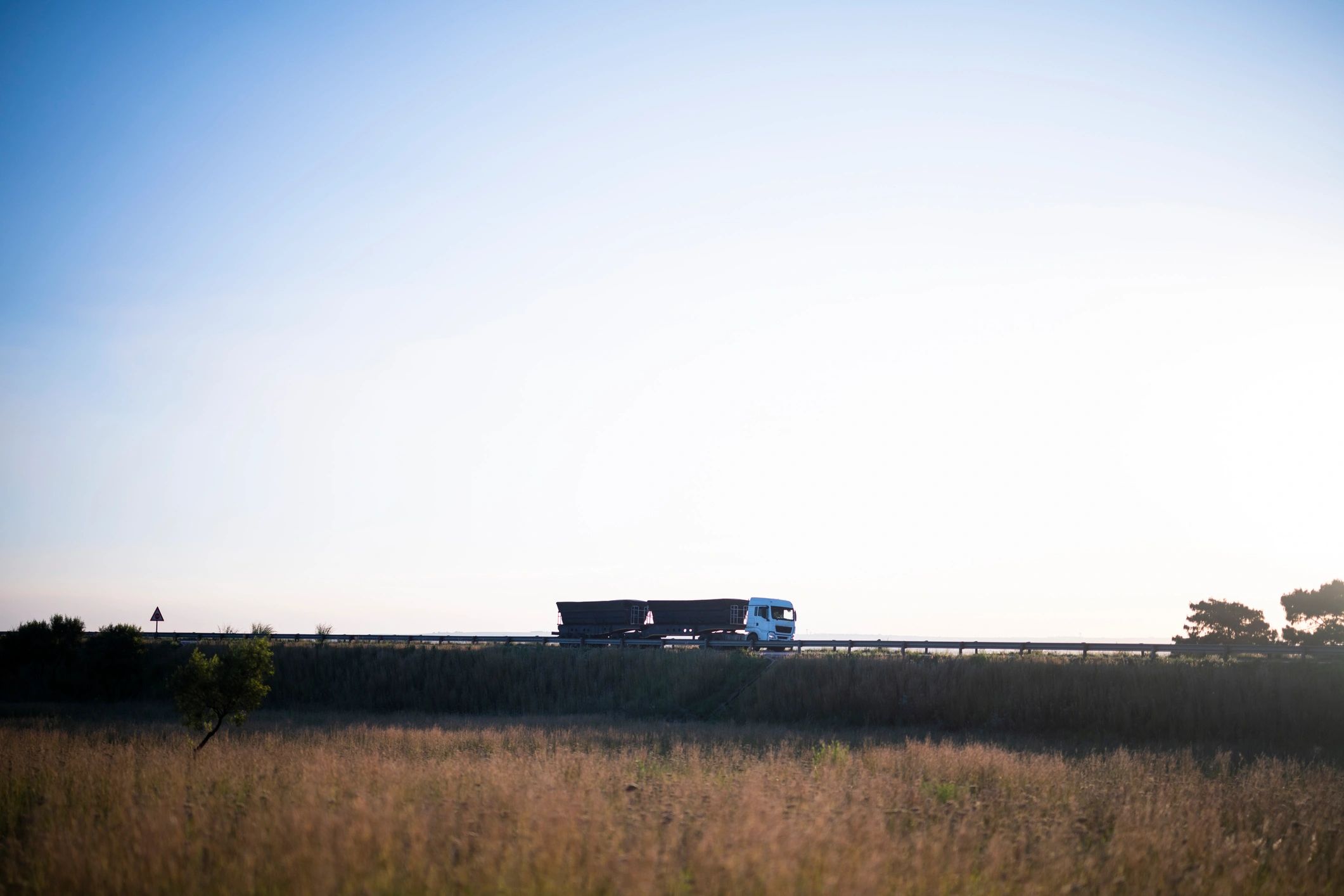 Long-haul truck on a highway at sunrise