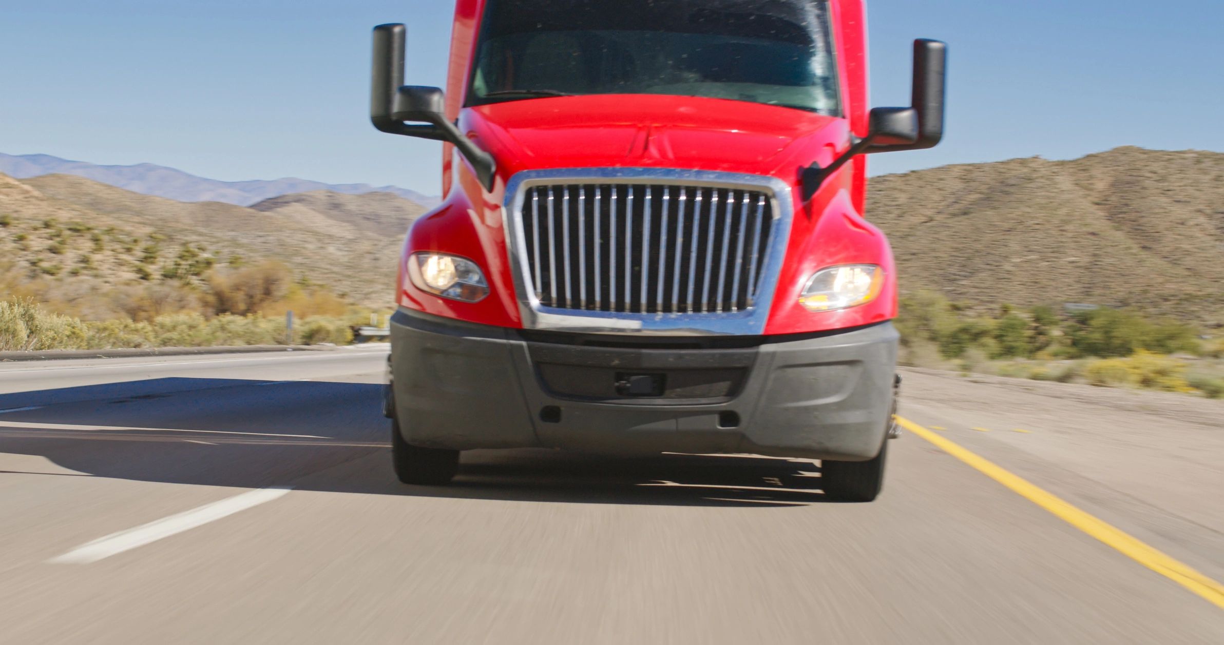 Red semi-truck traveling on an open highway